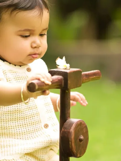A close-up of a baby playing with a wooden toy during an outdoor session. We focus on capturing their curiosity and interaction with the natural environment.