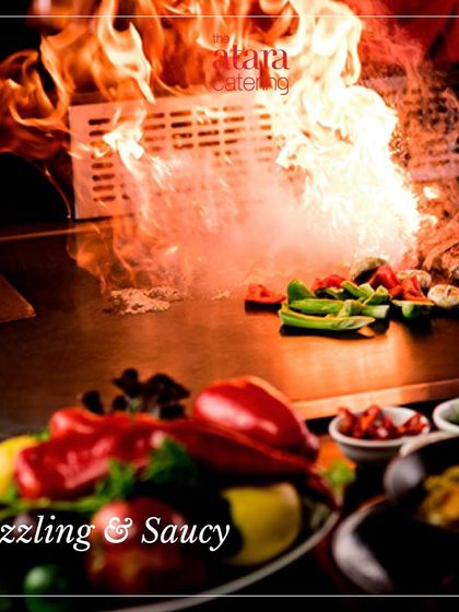 A sizzling and saucy Teppanyaki grill in full flame. This dramatic shot captures the excitement and high energy of our live cooking experience.