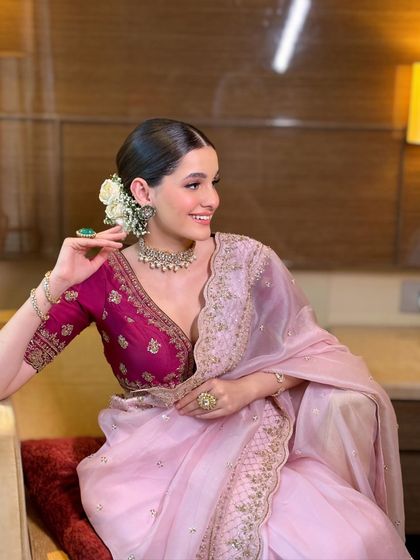 A joyful moment captured, showing the bride's beautiful smile and the graceful drape of her pink saree. This look is timeless and perfect for any festive occasion.