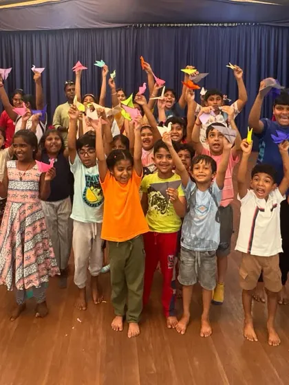 The joy of creation is clear on the faces of our students during an origami session. Here, a large group proudly displays the paper animals they've just folded, showing the fun and collaborative spirit of our kids' craft workshops.