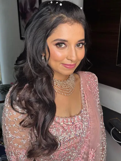 A close-up portrait. The shimmery eyeshadow and perfectly blended skin give her a radiant and polished look.