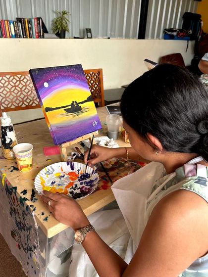 A participant paints a romantic sunset scene during our Valentine's Day workshop. The vibrant colors and serene subject make for a beautiful piece of art.
