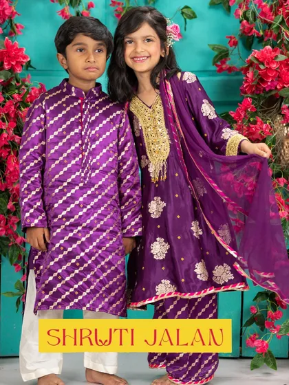 Creating coordinated outfits for brothers and sisters is one of my greatest joys. This vibrant purple set features a silk kurta with diagonal zari work for him and a matching sharara with intricate gold embroidery for her, perfect for a wedding or festive event.