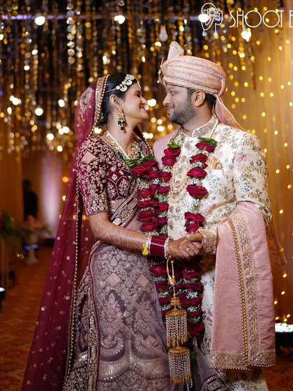 A classic romantic portrait of the couple amidst the warm glow of decorative lights, perfect for a wedding album.