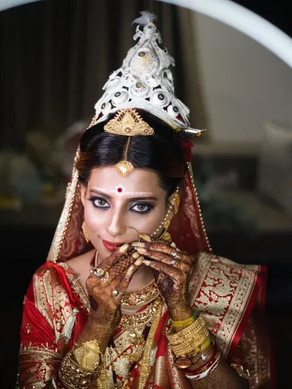 A close-up bridal portrait focusing on the delicate details of the 'mukut' and the bride's expressive eyes.