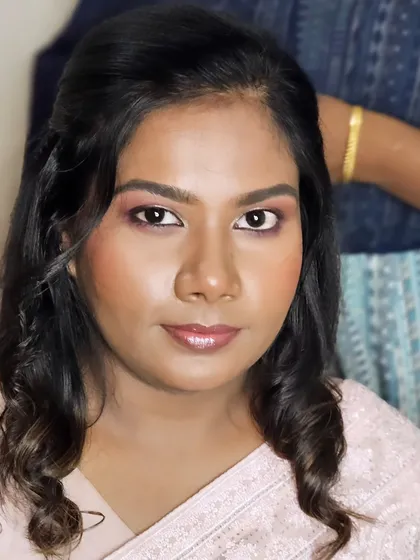 A close-up of a soft reception look. The eye makeup has hints of pink and brown, and the lips are a glossy nude, creating a fresh and modern style.