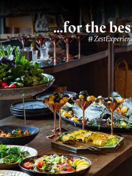 An elegant buffet spread featuring salads, grilled fish, and rolled appetizers.