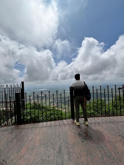 A trekker looking out from a viewpoint at Nandi Hills, which we often pair with our Adiyogi trip.