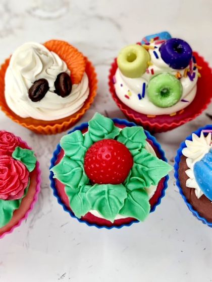 A collection of five different cupcake soap designs, from fruity loops to elegant roses, made using cold process soap and soap frosting.