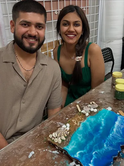 A happy couple proudly displaying the ocean-themed resin art they created together in one of my workshops. It's a great activity for a date, allowing you to collaborate on a piece of decor for your home while making a fun memory.