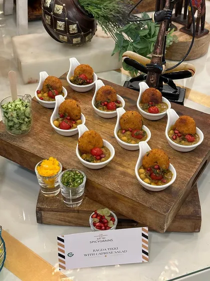 An elegant, single serving appetizer perfect for a Rakhi celebration. This is our Balezin Tikki with Caprese Salad, a fusion dish that combines Indian flavors with Italian freshness, beautifully presented on a wooden board.