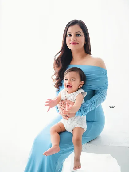 A beautiful portrait of a mother and her happy baby. Her smile says it all!
