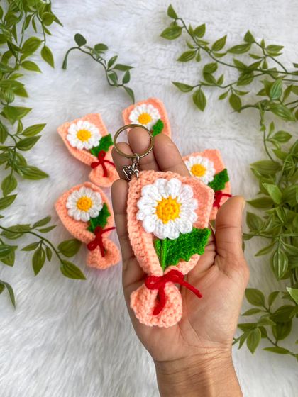 Holding one of the mini daisy bouquet keychains. It shows how delicate and cute these little charms are.