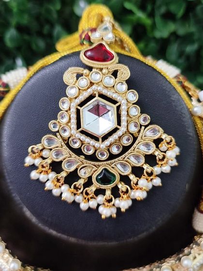 A detailed look at the pendant of a necklace from my exclusive sale collection. It features a central hexagonal polki stone surrounded by smaller kundan and pearl details.