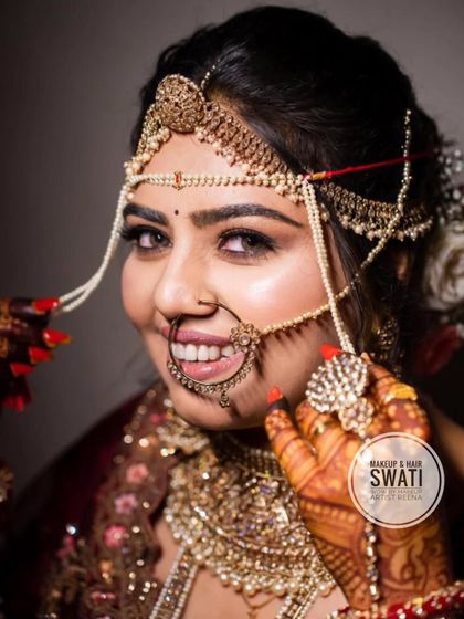 A close-up of Henoy's bridal smile. The large traditional nath and sparkling jewellery make a beautiful statement.