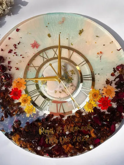 A full view of the colorful garland preservation clock. The mix of different flowers and a two-tone resin background makes this a truly unique piece.