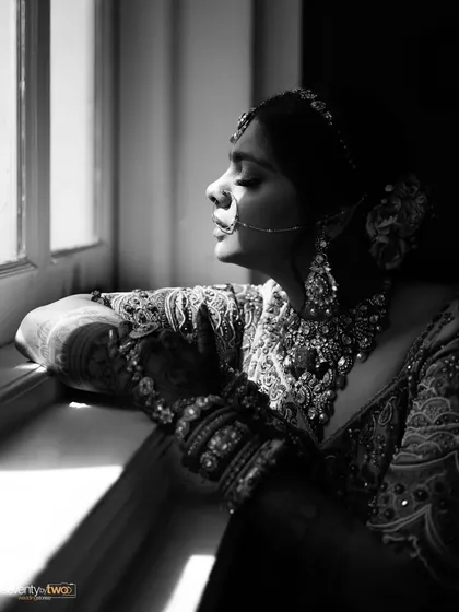 A bride caught in a moment of quiet reflection by a window. This black and white portrait uses natural light and shadow to create a timeless, soulful image.