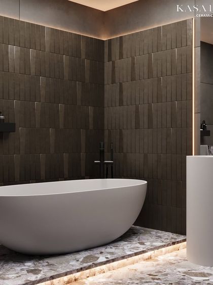 A freestanding tub set against a backdrop of textured vertical tiles and a terrazzo-style floor. The under-lighting on the tub platform highlights the unique pattern of the floor, adding another layer of luxury.