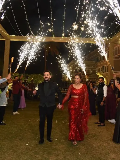 A simple yet sparkling entry for a cocktail night. The couple walks hand-in-hand through a tunnel of guests holding sparklers, creating an intimate and celebratory vibe.