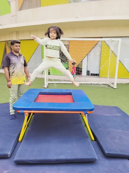 A student shows her determination while jumping on the trampoline during a gymnastics session. These activities are designed to be both fun and beneficial for developing physical agility and confidence.
