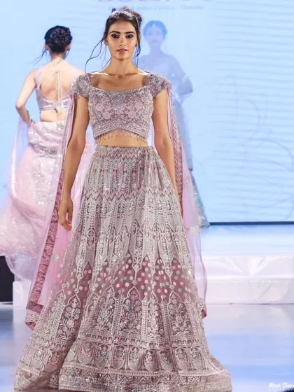 A model walks the ramp for 'Shaadi by Marriott Bonvoy' in a breathtaking lavender lehenga. This shot focuses on the garment's detail and the model's confident stride.
