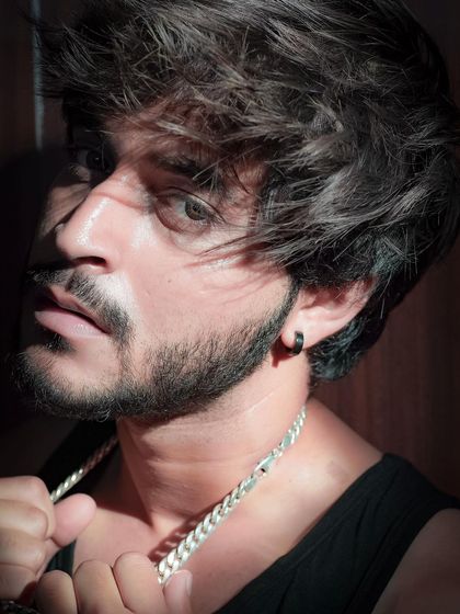 An intense close-up portrait using dramatic light and shadow. This shot highlights facial features and showcases a model's ability to deliver a powerful, edgy look.