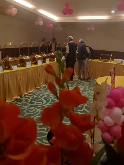 A birthday party setup in an indoor banquet hall. The pink balloon decor shows how we adapt our catering to any private celebration, making it special and memorable.