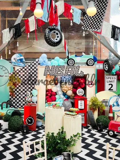 For high-energy celebrations, I design detailed themes like this race car party. The setup includes a custom-floored track, a full stage with a gas station prop, and themed seating to make every little guest feel like a champion.