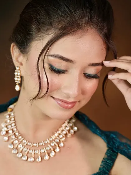 A close-up of a delicate Kundan necklace, perfect for a subtle and elegant look for an engagement or pre-wedding photoshoot.