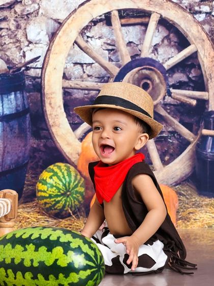 This happy little cowboy is ready for a day on the farm. The watermelons and pumpkins add a touch of harvest-time charm.