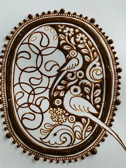 Another angle of the completed parrot cutwork mehendi, highlighting the intricate floral and vine details surrounding the birds.
