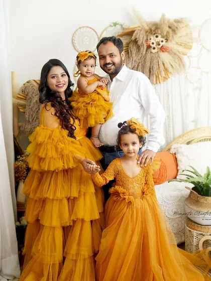 A happy family of four. The parents' loving gaze and the children's sweet poses make this a heartwarming and memorable family portrait.