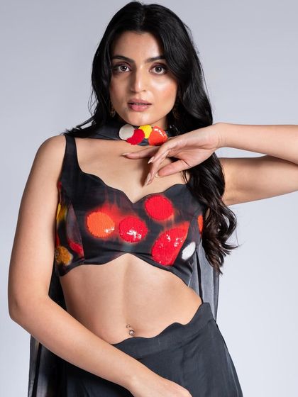 A close-up of a more playful look from the campaign. The makeup is clean and simple, allowing the colorful, abstract print of the top to be the main focus.