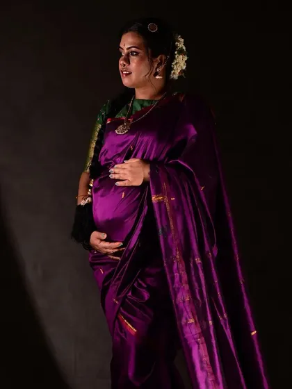 Another angle from the studio maternity shoot, showing the beautiful sheen of the silk saree and the way the makeup complements its rich color.