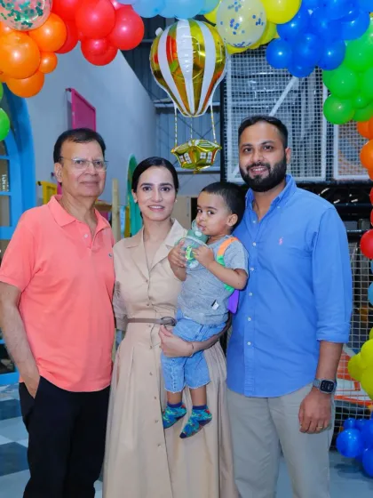 A beautiful multi-generational family photo taken at a colorful birthday party.