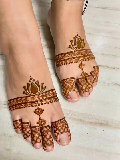A chic and modern foot mehendi design. The lotus motif with a toe-ring style pattern is both elegant and stylish.