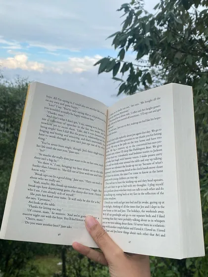 A book held open against the mountain landscape. Here, reading is not an escape from life, but a deeper engagement with it.