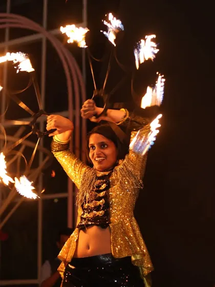 Wielding fire fans during a performance at Macaw by Stories. This prop allows for a dance-like flow, combining graceful movements with the intense beauty of live flame, perfect for up-close entertainment.