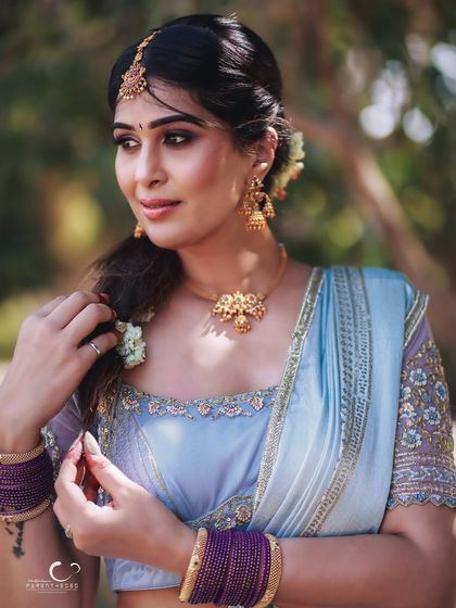 A delicate and thoughtful pose, as if adjusting her hair. This candid-style portrait feels intimate and captures a moment of quiet grace.