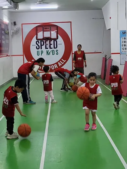 A group of young kids practicing their basketball dribbling. Our coaches are always on hand to help and guide them.