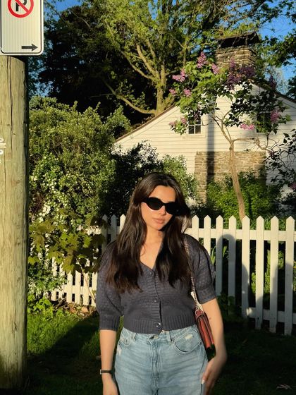 A sunny outdoor shot featuring a casual top and jeans.