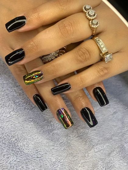 A chic and edgy set of square extensions. Most nails are a glossy jet black, with two accent nails featuring a stunning multi-tonal chrome finish.