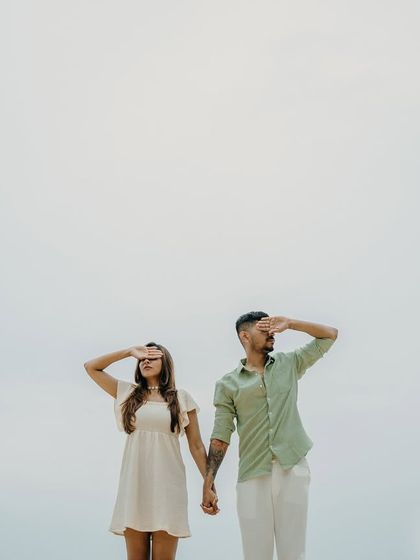 A minimalist and quirky portrait against the open sky in Thailand. This kind of creative shot adds a unique and modern touch to a couple's pre-wedding photography collection.