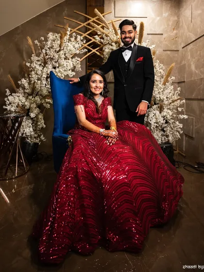 A regal reception portrait. The couple's pose is formal and elegant, and the bride's red gown is absolutely stunning.