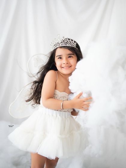 A beautiful portrait of a little angel with a sparkly tiara and delicate wings.