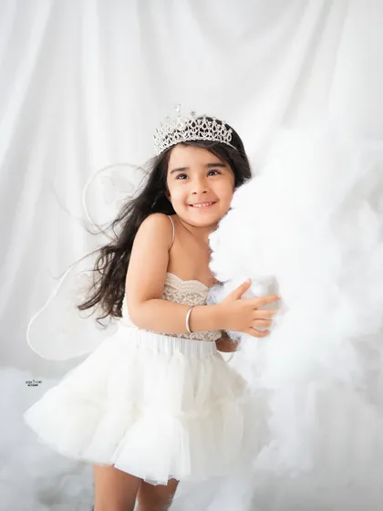 A beautiful portrait of a little angel with a sparkly tiara and delicate wings.