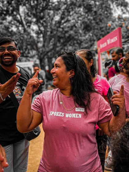 Pure joy and energy at our Garage Sale. A member dances and celebrates in her pink 'Spokes Women' T-shirt.
