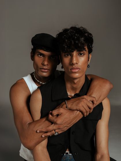 A color version of the dual-model portrait, offering a different mood. The warmth of the skin tones contrasts with the neutral clothing, highlighting the human element within the fashion story.