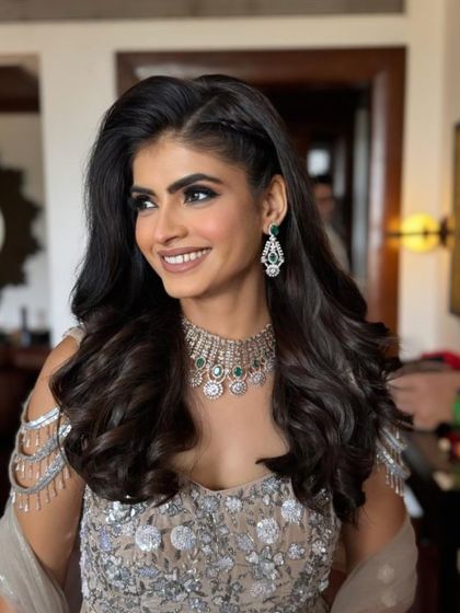 My beautiful client looking radiant for a wedding event. I gave her a soft glam makeup look with a focus on glowing skin and paired it with a stylish half-up hairstyle with braids and waves.