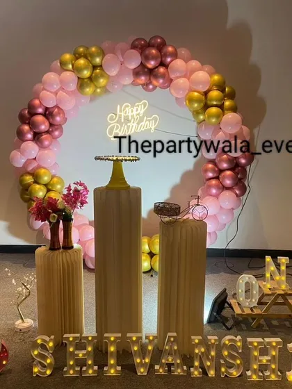 A lovely ring decoration with shades of pink and gold. The setup is arranged in a semi-circle on the floor, creating a cozy and inviting photo corner.